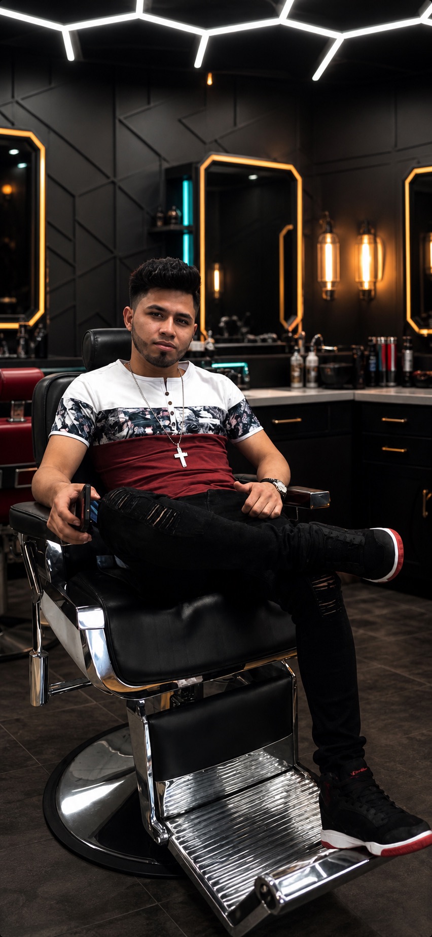 Ludvin Morales, owner of Morales Barbershop MB, sitting in one of the chairs in the shop
