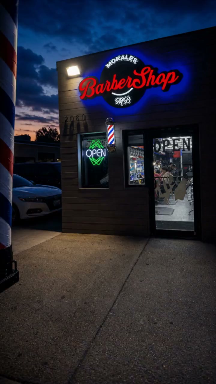 Inside Morales Barbershop MB in Hyattsville, the barber stations with red chairs under the glowing honeycomb ceiling