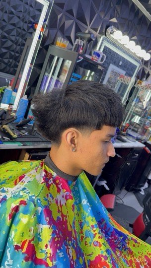 Edgar cut with a straight fringe in front and tapered, faded sides.