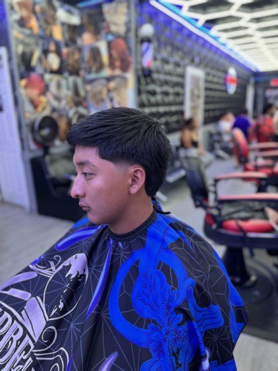 Mid fade with a clean line up on the forehead and sideburns.