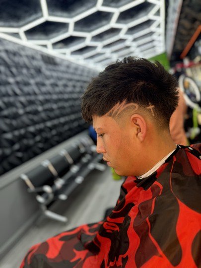Mid fade with a shaved part and a textured top.