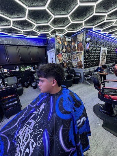 Mid fade with a textured top, side view in the shop.