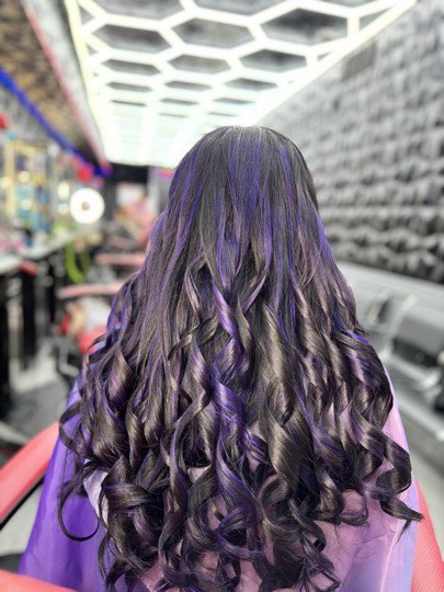 Long wavy hair dyed lavender, seen from behind.