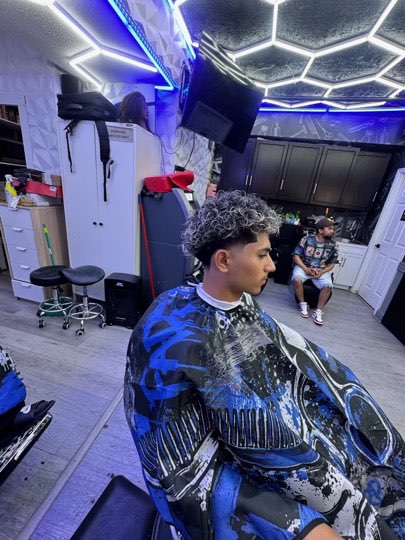 Curls with bleached tips and a mid fade on the sides.