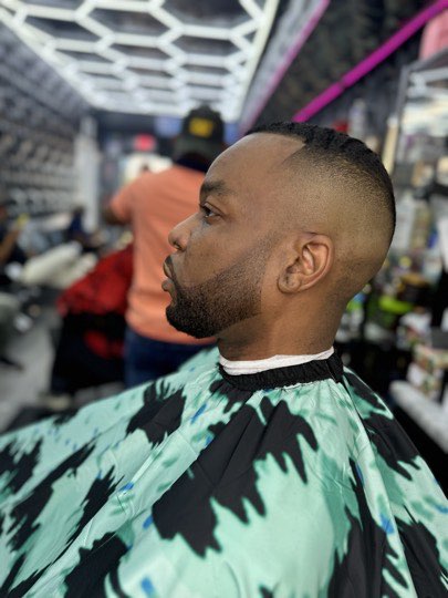 High skin fade with a trimmed beard and a straight line up.