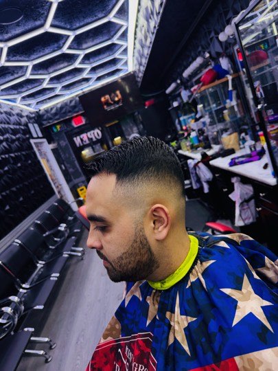 High skin fade with a flat top and a connected beard.