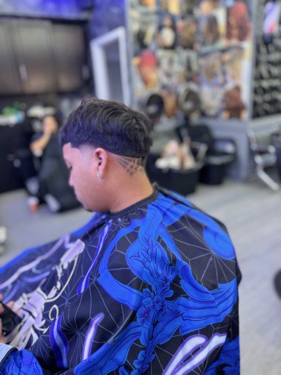 Low taper with a shaved line above the ear.