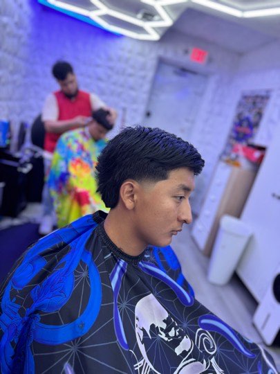 Taper fade with a textured top and a clean line up in front.