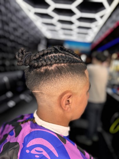 Braids pulled into buns with a skin fade and the shaved line.